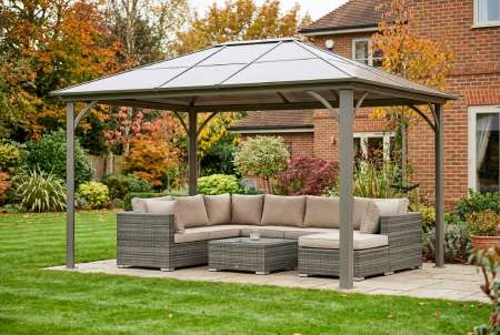 Weatherproof gazebo shelter over a rattan outdoor garden furniture set with cushions in a suburban British backyard